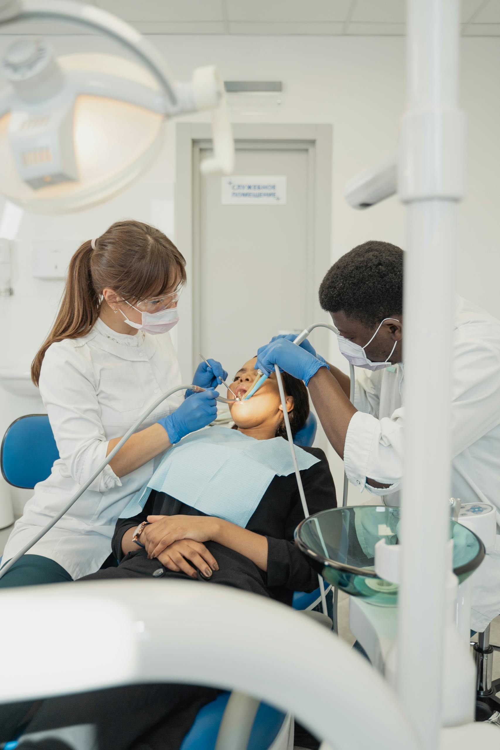 Professional dental care with a dentist and assistant attending to a patient in a clinic.